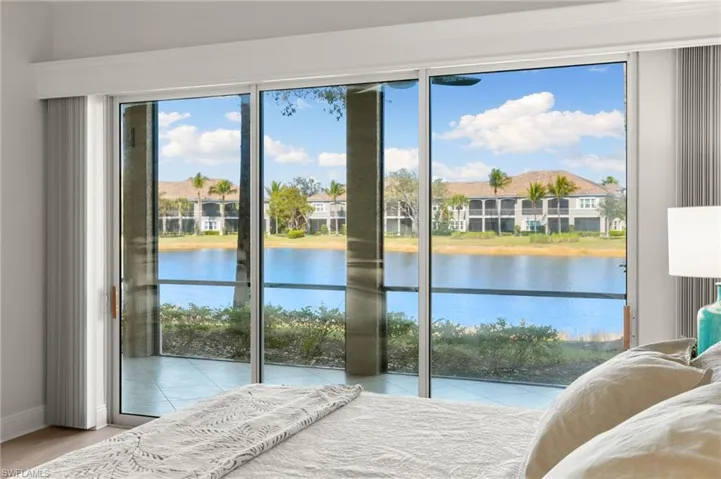 Bedroom featuring access to exterior, a water view, and light wood finished floors