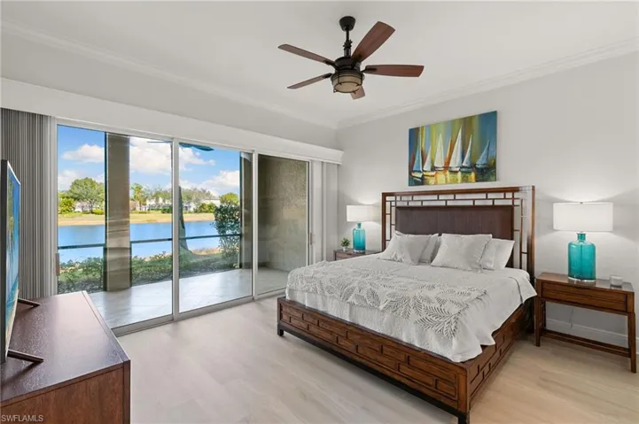 Bedroom featuring a water view, light wood-style flooring, ornamental molding, access to exterior, and ceiling fan