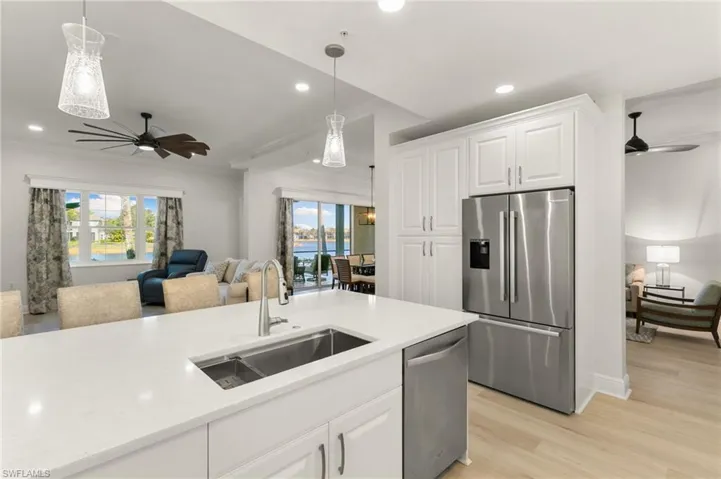 Kitchen with a ceiling fan, white cabinetry, stainless steel appliances, and crown molding