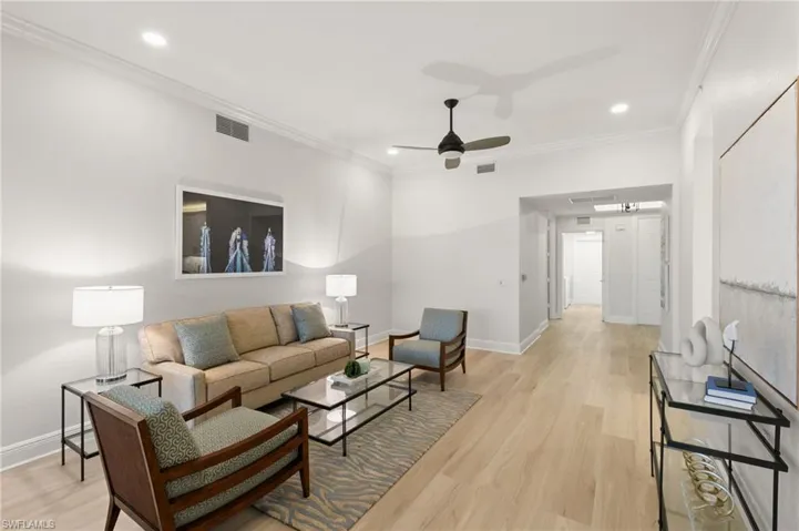 Living area featuring ornamental molding, light wood-style flooring, a ceiling fan, and recessed lighting