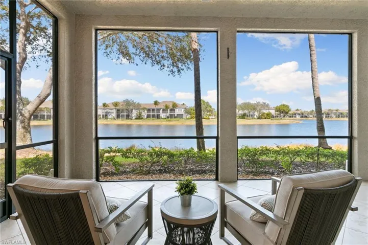 Sunroom / solarium with a water view and tile patterned floors