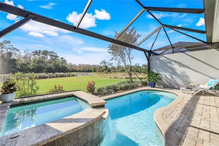 View of swimming pool featuring a lanai, a patio area, and a lawn
