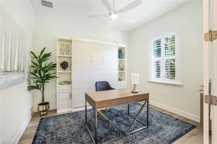 Office space featuring a murphy bed and ceiling fan and wood-type flooring