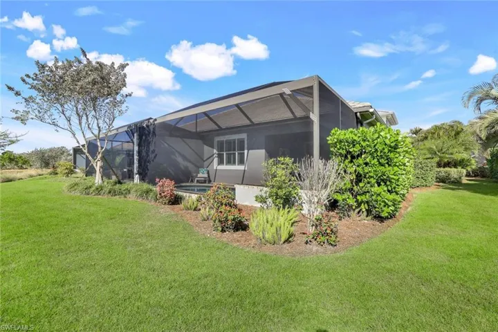 Rear view of property featuring a yard and a lanai