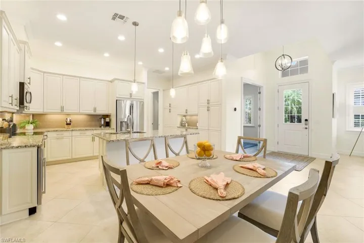 Dining room featuring light tile patterned floors, an inviting chandelier, ornamental molding, and sink