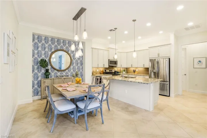 Dining area with light tile patterned floors, crown molding, and sink