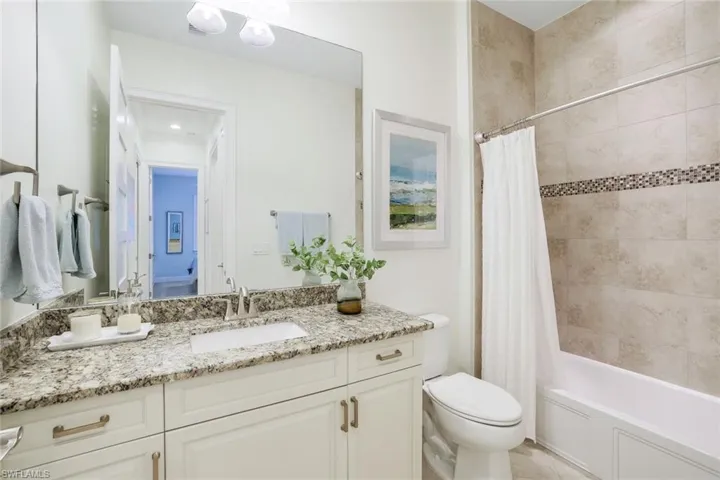 Full bathroom with shower / tub combo, vanity, and toilet