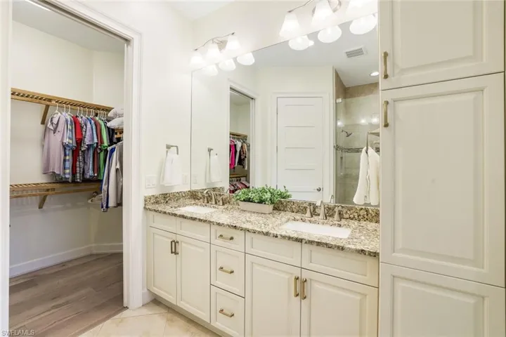 Bathroom featuring tile patterned floors, vanity, and an enclosed shower