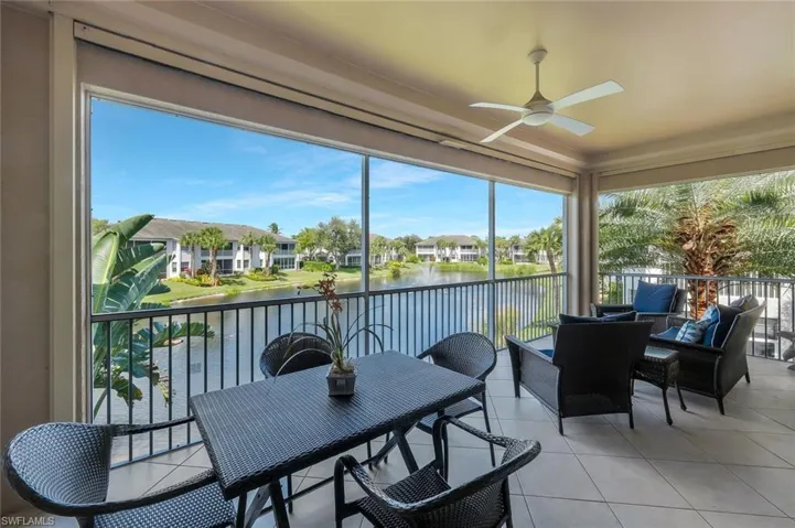 Screened lanai overlooking the peaceful lake and water feature, offering the perfect setting for morning coffee or evening relaxation.