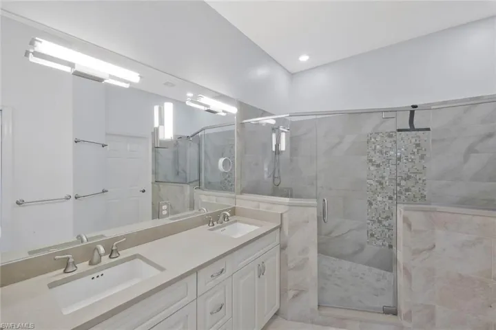 Beautifully updated primary bathroom featuring modern finishes and a spacious walk in shower.