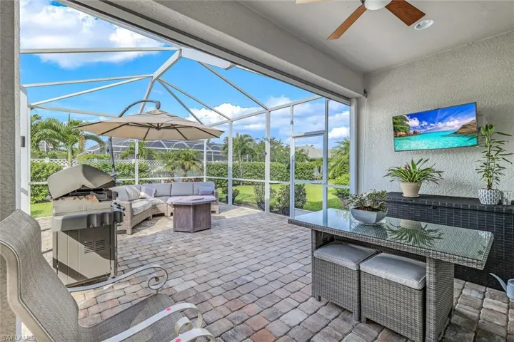 View of patio with ceiling fan, area for grilling, an outdoor hangout area, and a lanai