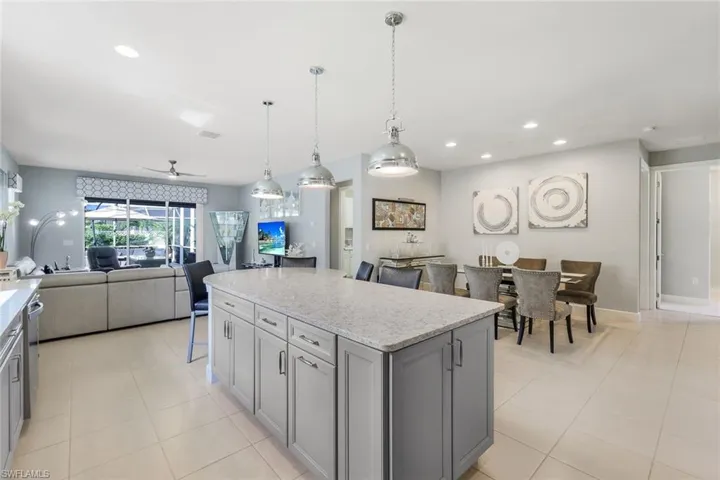 Kitchen with a center island, ceiling fan, light tile patterned flooring, and hanging light fixtures