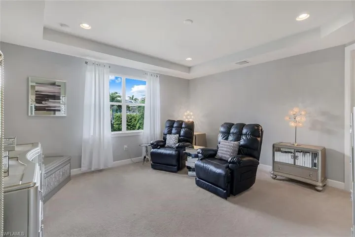 Sitting room with a raised ceiling and light carpet