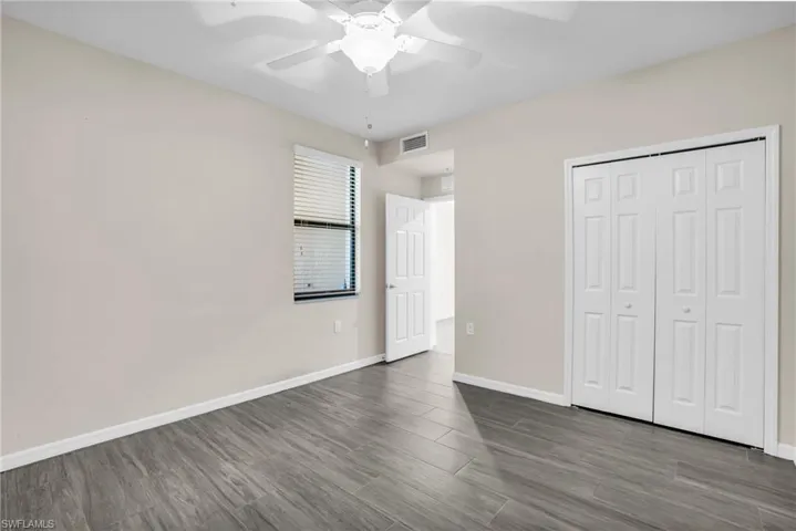 Unfurnished bedroom with a closet, wood tile flooring, and ceiling fan