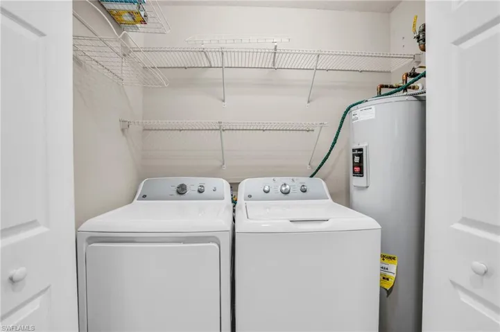 Laundry room with washer and clothes dryer and water heater