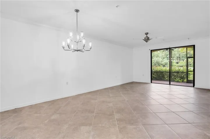 Tiled living room with crown molding and ceiling fan with notable chandelier