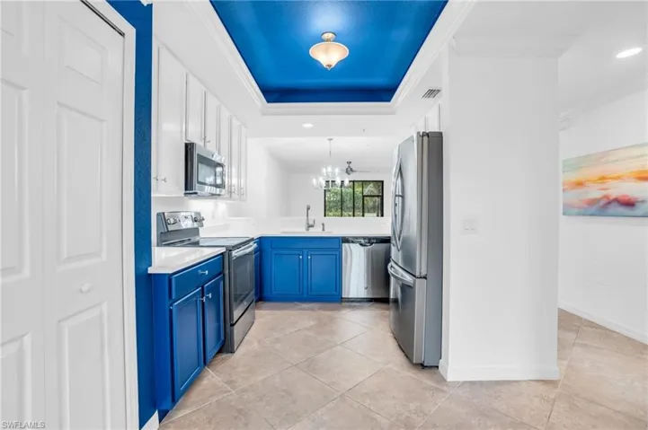 Kitchen featuring sink, blue cabinets, stainless steel appliances, and light tile patterned floors