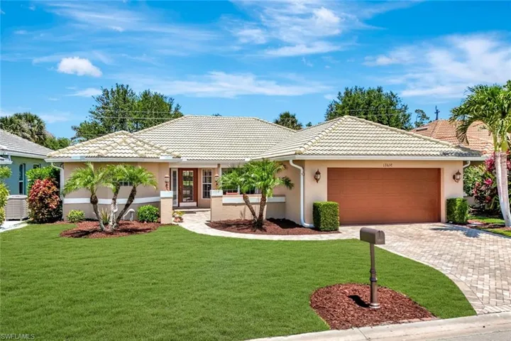 Ranch-style home with a garage, stucco siding, a tiled roof, and a front yard