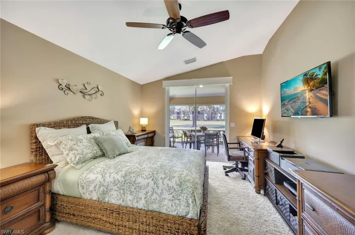Bedroom featuring a ceiling fan, access to exterior, visible vents, lofted ceiling, and light carpet