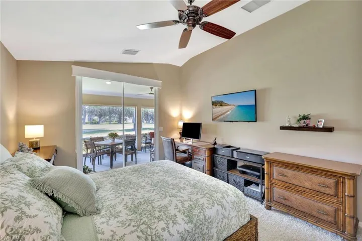 Carpeted bedroom with access to outside, a ceiling fan, lofted ceiling, and visible vents