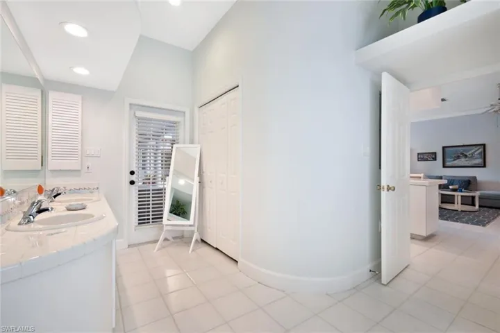 Bathroom with tile patterned flooring, dual vanity, and ceiling fan