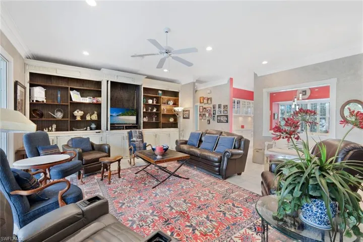 Tiled living room featuring a healthy amount of sunlight, ceiling fan, and ornamental molding