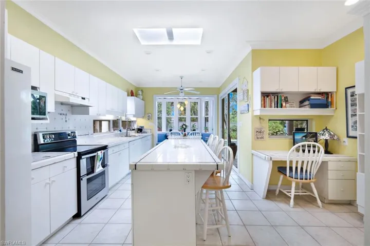 Kitchen featuring double oven range, a kitchen breakfast bar, white cabinets, and a kitchen island