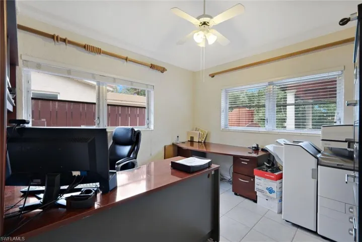 Office space with ceiling fan, light tile patterned floors, and plenty of natural light