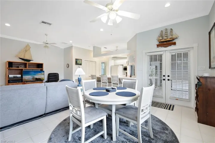 Tiled dining area with french doors, ceiling fan, and ornamental molding