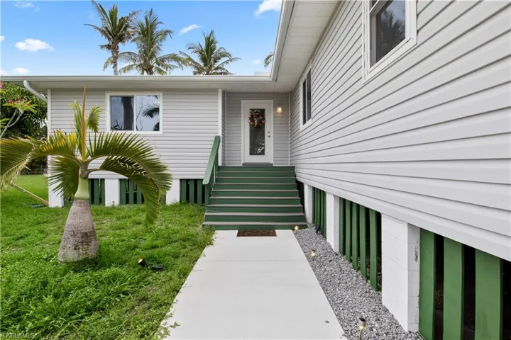 Curb appeal alert!  Beautiful trex deck stairs with impact windows throughout the home and a glass door to allow the natural light  in!