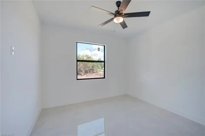 Spare room featuring baseboards and ceiling fan