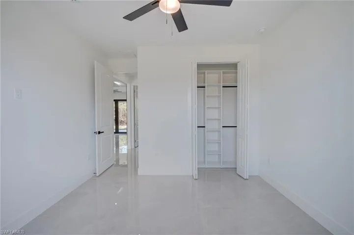 Unfurnished bedroom featuring ceiling fan and a closet