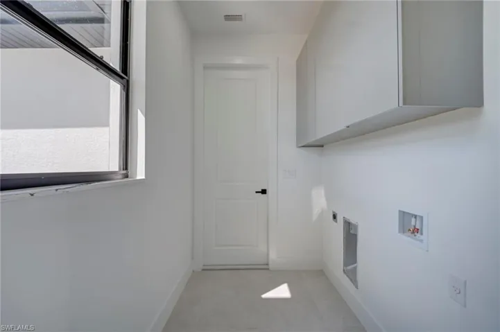 Laundry area with cabinet space, hookup for a washing machine, and hookup for an electric dryer