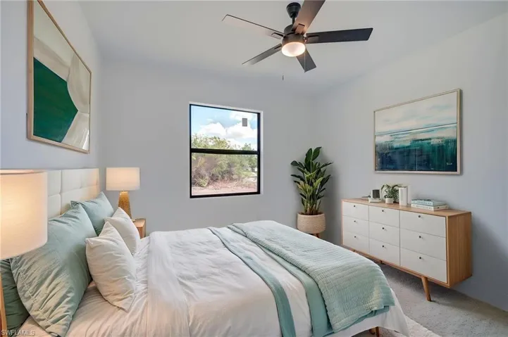 Carpeted bedroom with a ceiling fan