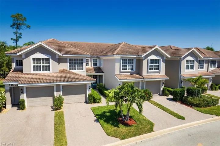 View of front of home featuring stucco siding, decorative driveway, a tiled roof, and a garage
