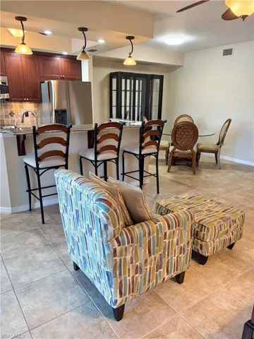 Living room featuring a ceiling fan, light tile patterned floors, and recessed lighting