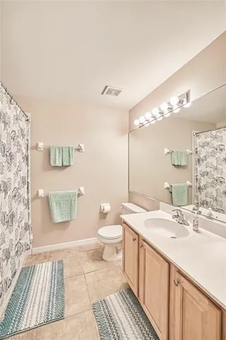 Bathroom with vanity, light tile patterned floors, and a shower with shower curtain