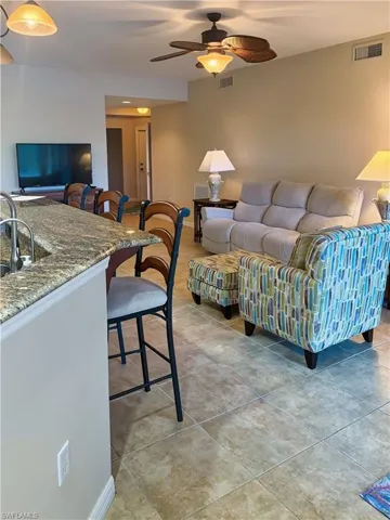 Living area featuring ceiling fan and light tile patterned floors