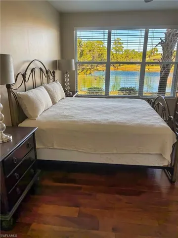 Bedroom featuring dark wood-type flooring and a water view