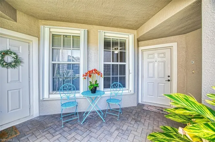 View of exterior entry with stucco siding and covered porch