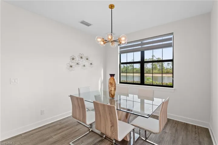 Unfurnished dining area featuring light wood-style flooring, a chandelier, and a water view