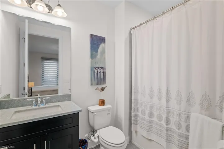 Full bath featuring vanity and shower / tub combo with curtain