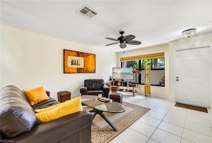 Living room featuring tile patterned flooring and a ceiling fan