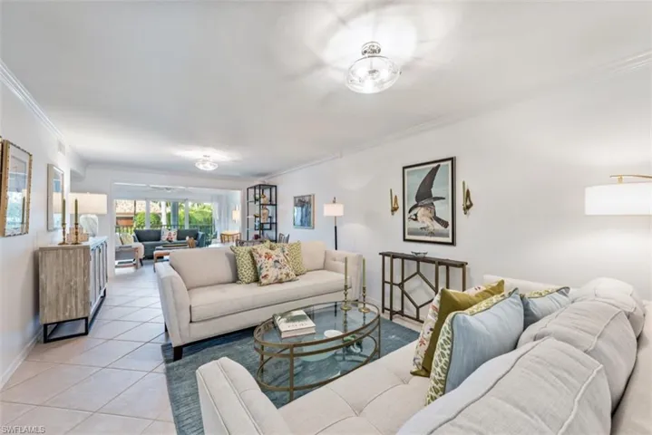 Living room with ornamental molding and light tile patterned floors