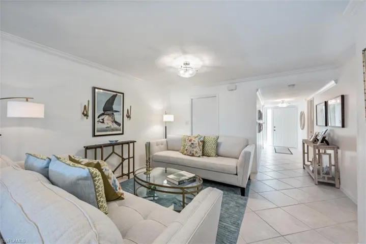 Tiled living room featuring crown molding