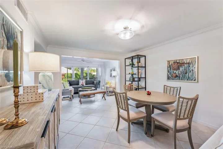 Dining space with crown molding, light tile patterned flooring, and ceiling fan
