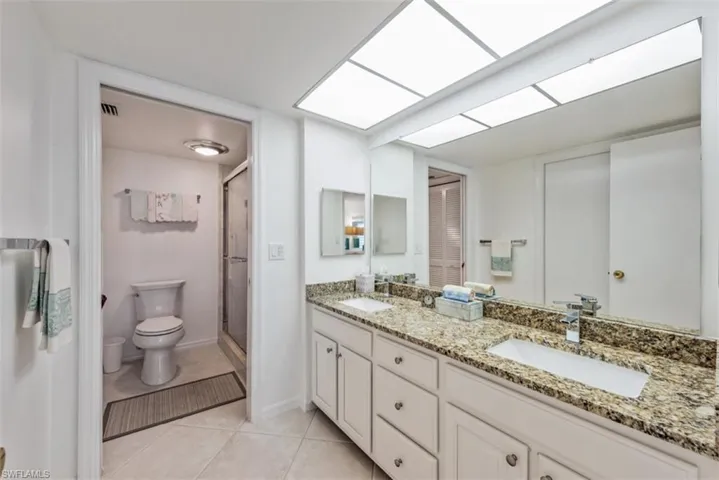Bathroom featuring tile patterned flooring, vanity, and walk in shower