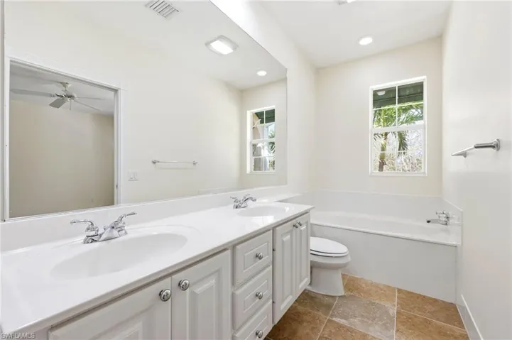 Full bathroom with double vanity and a bath