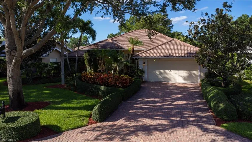 View of front facade featuring a garage and a front lawn
