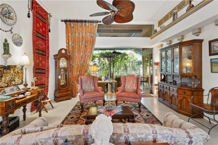 Living room featuring a towering ceiling, plenty of natural light, and ceiling fan